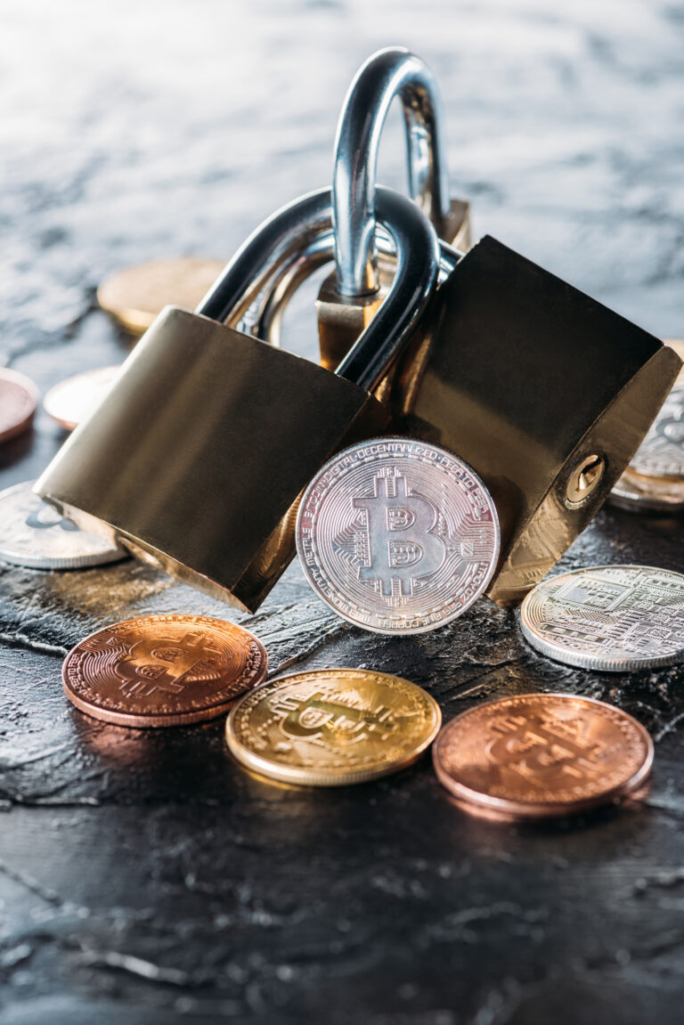 close up view of arranged locks and various bitcoins on dark surface